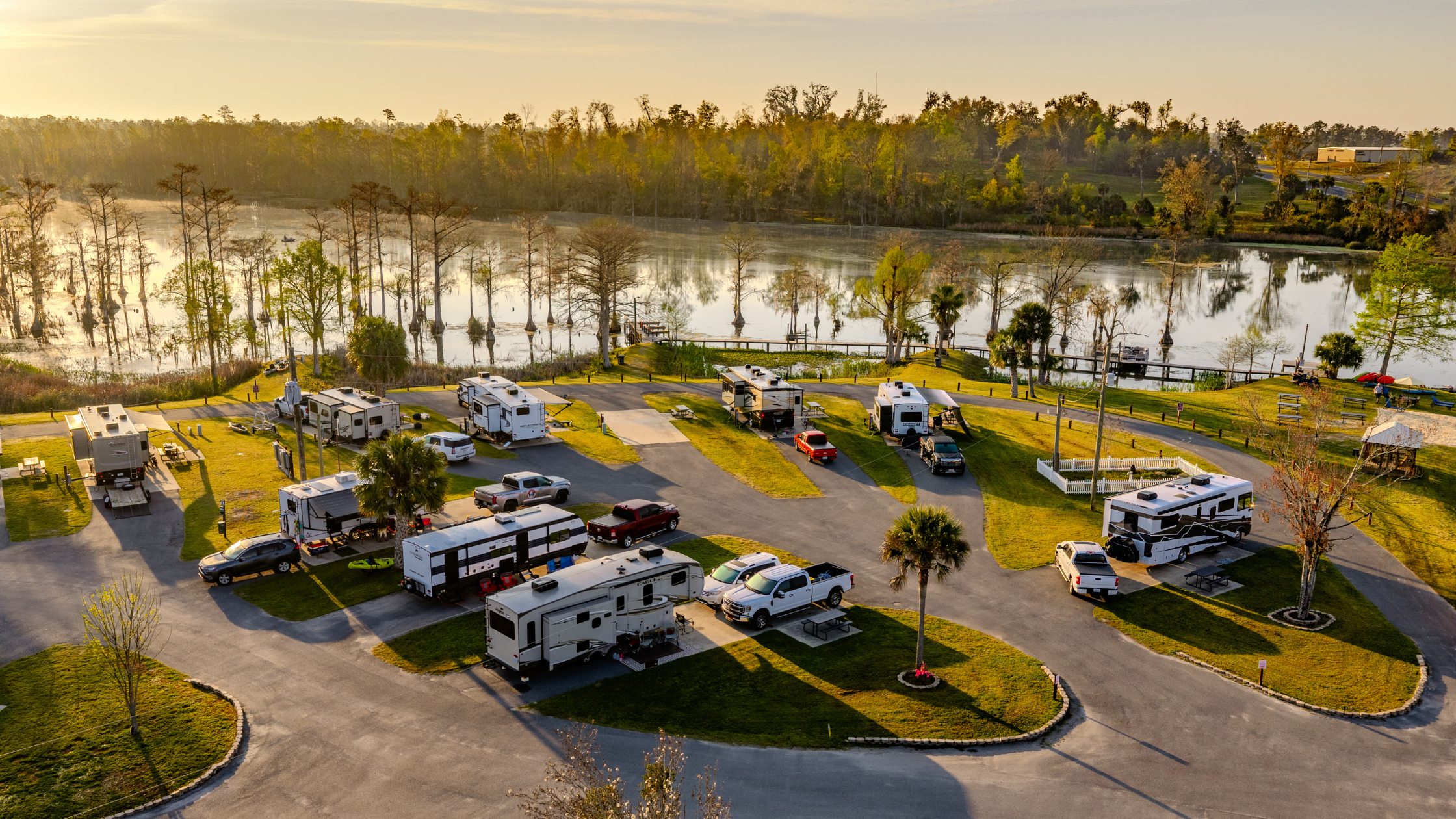 Aerial photo of the RV sites at Florida Caverns RV Resort with Merritt's Mill Pond in the background, it's the early morning